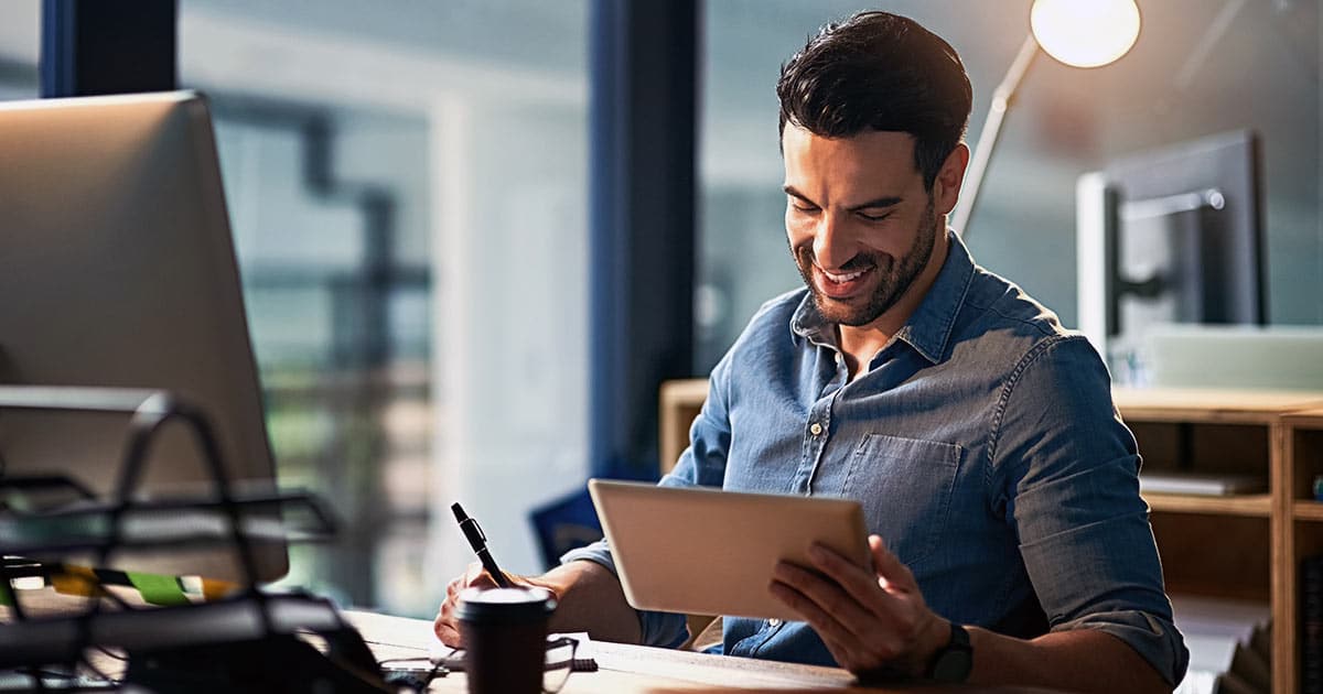 Man using desk computer and tablet